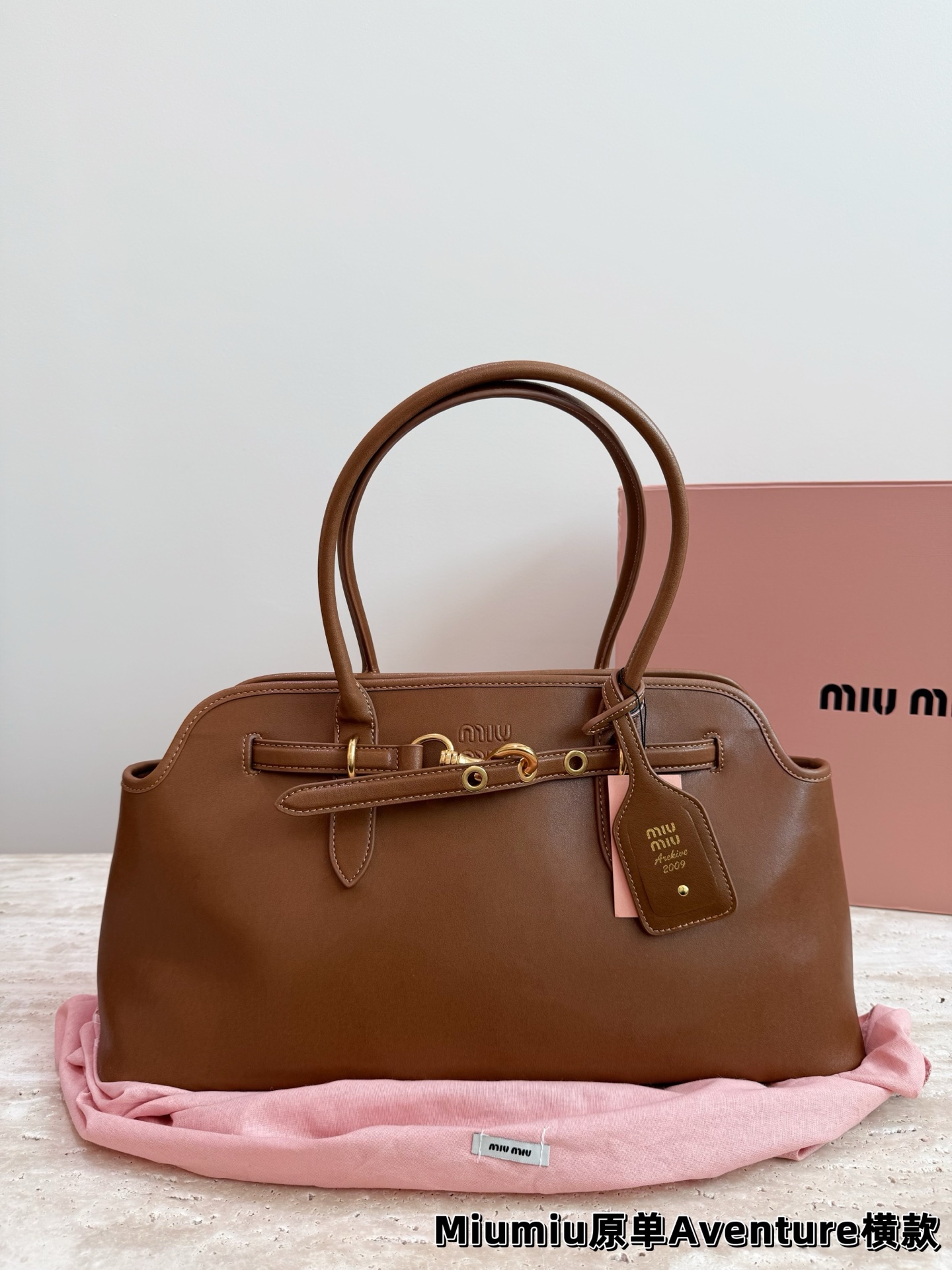 P240 miumiu复古Aventure系列贝壳包 Aventure系列贝壳手提/斜挎包.上线啦! 24ss最流行款式，做旧褪色感的皮革颜色与质地，配上金属皮带搭扣高级又复古，采用小牛皮制作的包身设计精致，方正复古的造型 手提腋下斜挎包随意切换! 优雅通勤超好穿快快加入miu女孩吧! 尺寸:超大号46*23cm复古包#牛皮包包