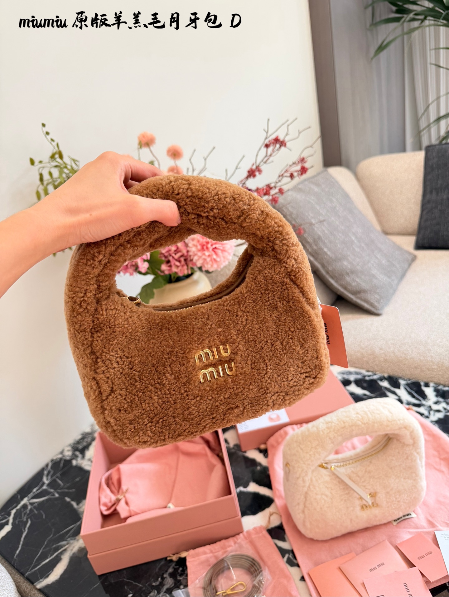 p255 Miu Miu羊羔毛Mini Wander手提包 &这款Miu Miu羊羔毛Mini Wander手提包,采用柔软羊 羔毛,触感超温暖,秋冬必备!奶茶色包身+金色L ogo刺绣,精致又有辨识度十。尺寸小巧,手提or肩背都OK,配有链条和肩带,百搭各种穿搭风格。内部空间刚好,手机、钥匙轻松收纳,实用又时髦。23cm配盒子