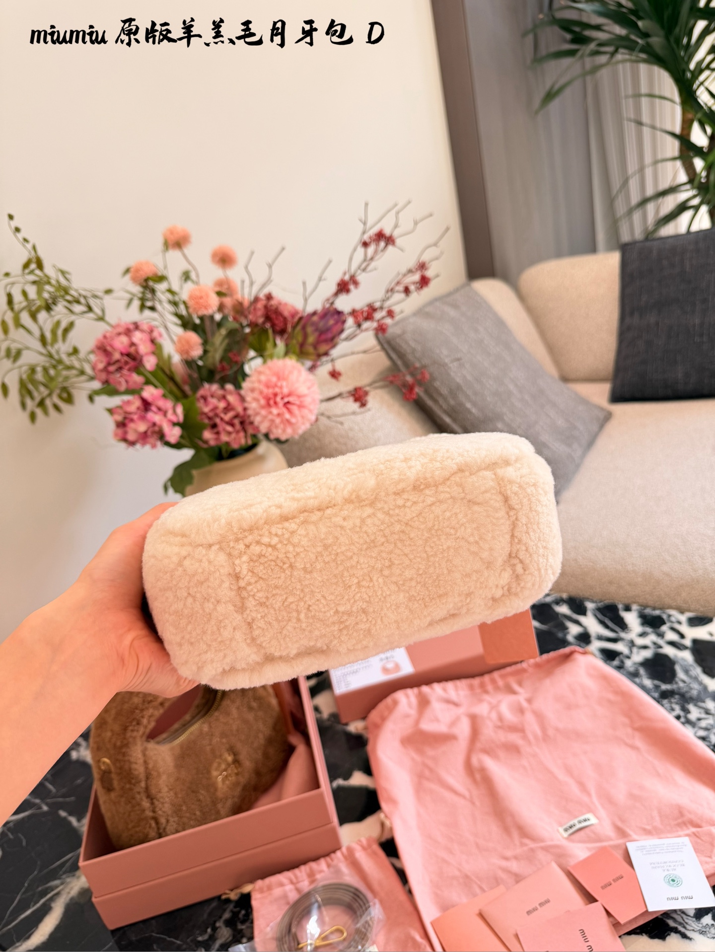 p255 Miu Miu羊羔毛Mini Wander手提包 &这款Miu Miu羊羔毛Mini Wander手提包,采用柔软羊 羔毛,触感超温暖,秋冬必备!奶茶色包身+金色L ogo刺绣,精致又有辨识度十。尺寸小巧,手提or肩背都OK,配有链条和肩带,百搭各种穿搭风格。内部空间刚好,手机、钥匙轻松收纳,实用又时髦。23cm配盒子