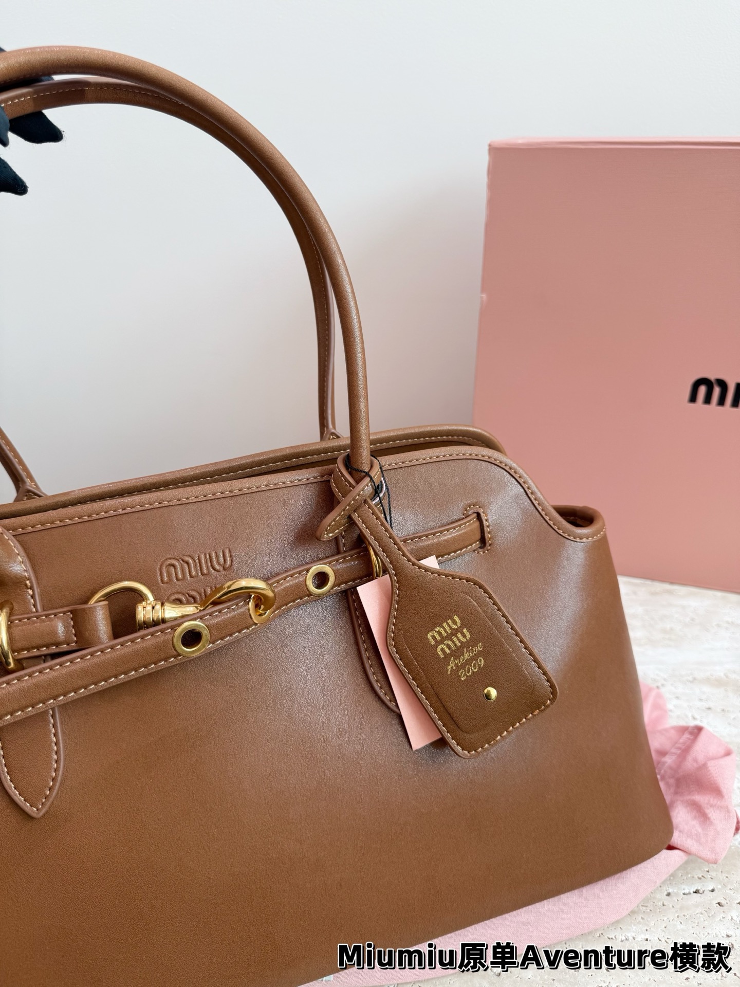 P240 miumiu复古Aventure系列贝壳包 Aventure系列贝壳手提/斜挎包.上线啦! 24ss最流行款式，做旧褪色感的皮革颜色与质地，配上金属皮带搭扣高级又复古，采用小牛皮制作的包身设计精致，方正复古的造型 手提腋下斜挎包随意切换! 优雅通勤超好穿快快加入miu女孩吧! 尺寸:超大号46*23cm复古包#牛皮包包