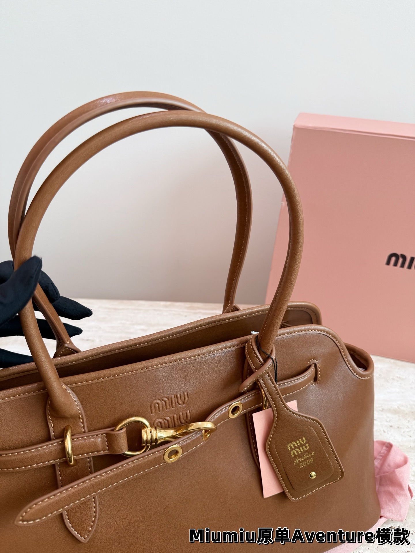 P240 miumiu复古Aventure系列贝壳包 Aventure系列贝壳手提/斜挎包.上线啦! 24ss最流行款式，做旧褪色感的皮革颜色与质地，配上金属皮带搭扣高级又复古，采用小牛皮制作的包身设计精致，方正复古的造型 手提腋下斜挎包随意切换! 优雅通勤超好穿快快加入miu女孩吧! 尺寸:超大号46*23cm复古包#牛皮包包