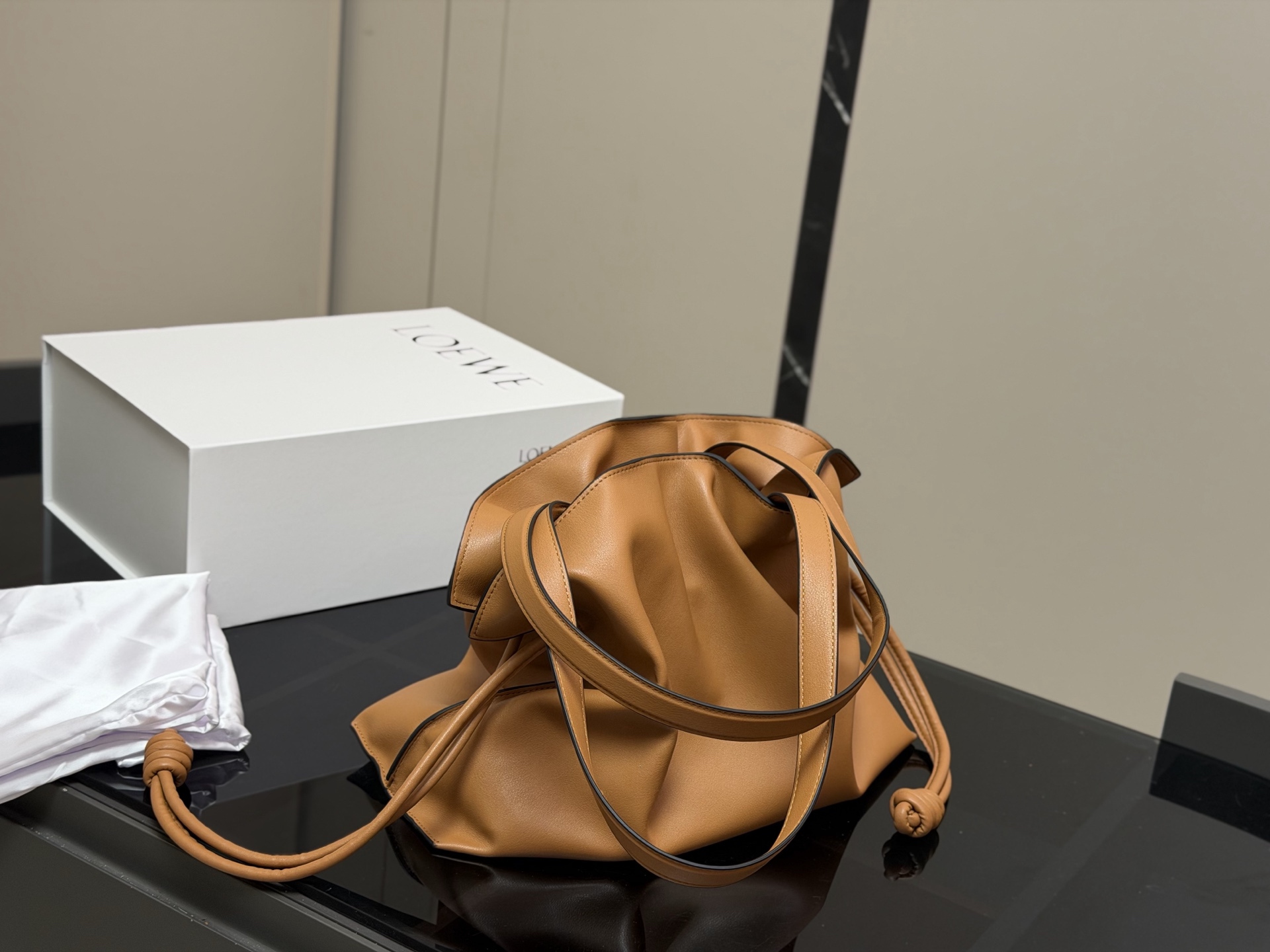 &yen;300 配折叠盒 LOEWE 罗意威Anagram福袋托特包 采用柔软纳帕牛皮，手感细腻，廓形随性慵懒。灵感源自日本福袋，抽绳设计方便开合，容量超大，通勤日常都很实用。肩带可调节，支持单肩或斜挎，搭配Anagram印花，低调又有辨识度，时髦精们必入！ 尺寸:37.29cm