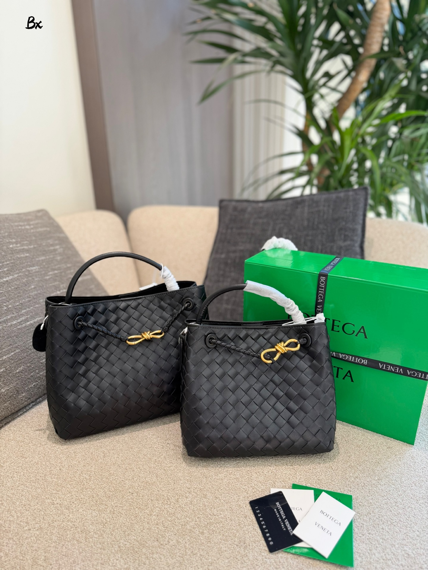 p235p255 BV Andiamo巴罗洛手袋​​ 🍷Bottega Veneta Andiamo系列手袋，巴罗洛酒红色超有质感，Nappa小羊皮+Intrecciato编织工艺，触感柔软细腻，纹理超美！金属绳结锁扣可调节，单肩、手拎、斜挎都OK，通勤日常都能用👜。小号&中号容量适中，实用又时髦，酒红色优雅复古，秋冬搭配超出片，是都市女生必入的高端手袋✨。25cm30cm配盒子