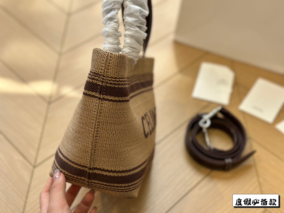 &yen;220 Celine新款编织托特包 Celine新款编织包是一款设计简洁而又不失时尚感的托特包。其最显著的特点在于采用了棕色粗细不均条纹的帆布材质，这种设计不仅赋予了包包独特的视觉冲击力，也展现了Celine品牌一贯的优雅与精致。在包的正面醒目地印有大写的&ldquo;CELINE&rdquo;字样，既凸显了品牌的身份，也提升了包包的整体美感。20*17