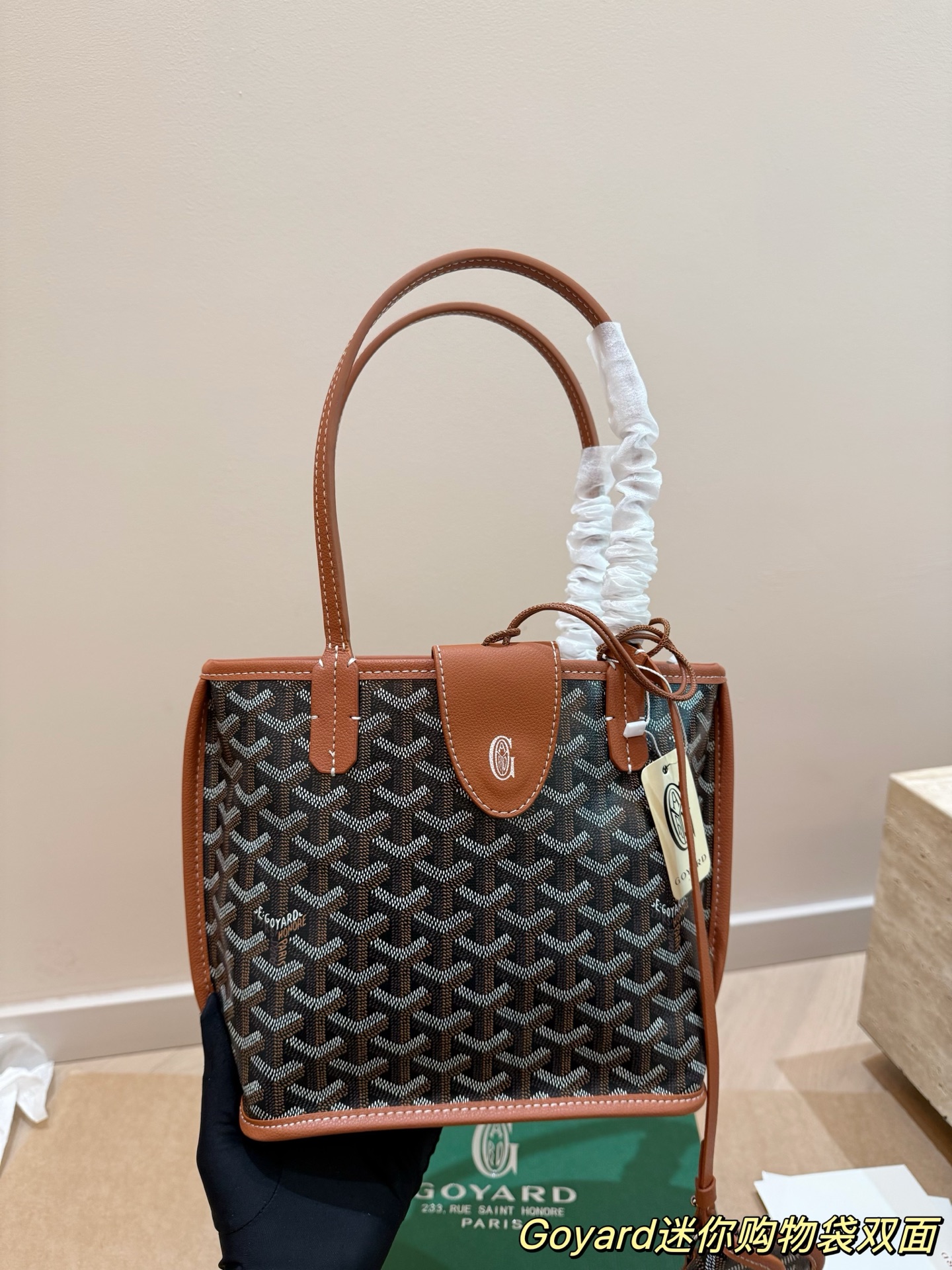P150 Goyard Goyardine手提包 法国奢侈品牌Goyard的Goyardine手提包，采用经典老花帆布+黑色皮革饰边，简约又超有辨识度t+。独特几何图案，轻便耐用，日常通勤或休闲都很适合!手提+可调节肩带，手提斜挎随心切换，实用又时髦。Goyard以高级定制和精湛工艺闻名，这款包袋收藏价值满满，时尚爱好者必入!20cm配盒子