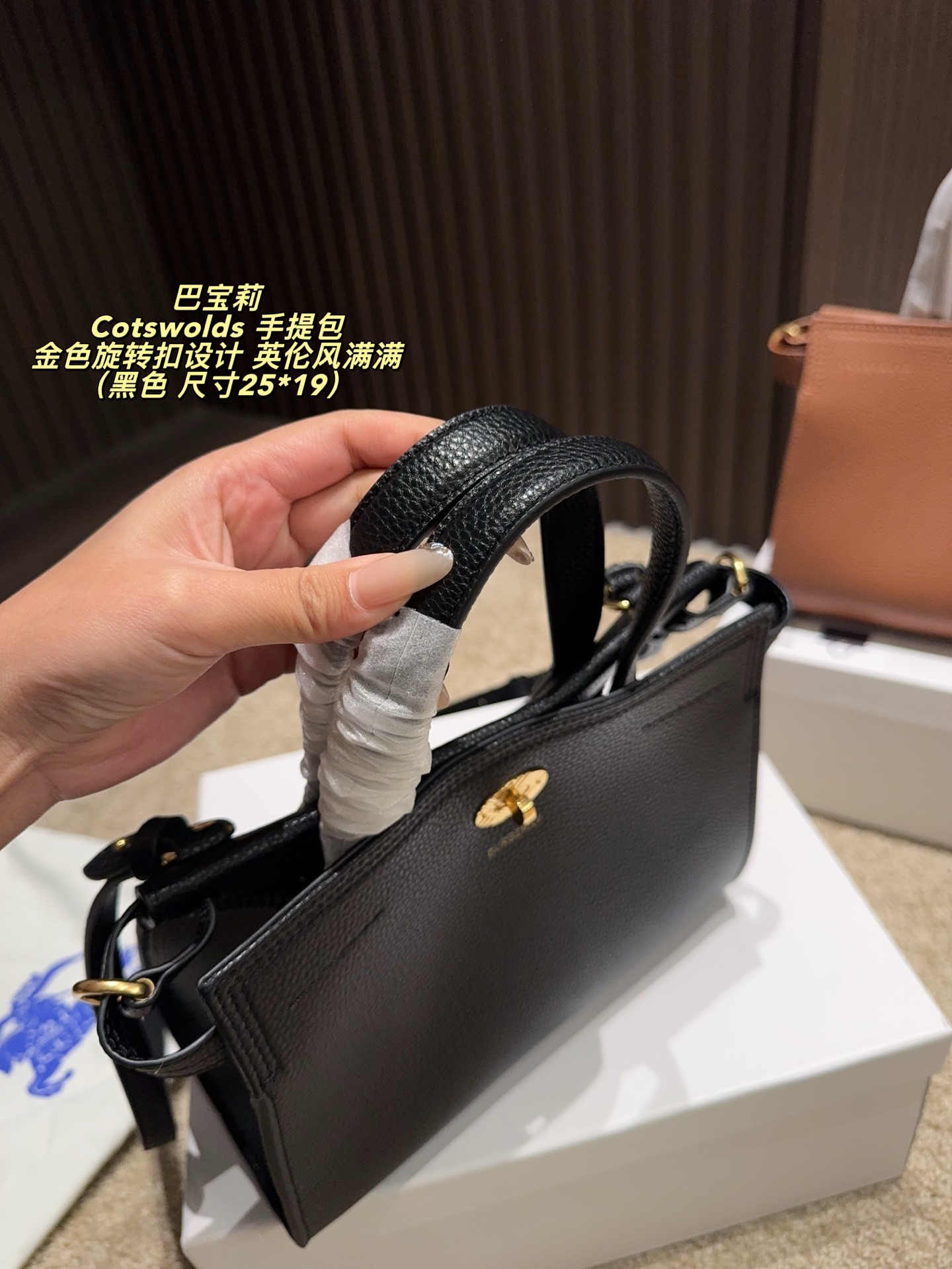 P220配盒⚠️尺寸25*19 Burberry 巴宝莉Cotswolds 手提包 采用粒面小牛皮，质感细腻耐用，低调奢华。金色旋转扣设计，英伦风满满，简约又精致。包身轻盈，容量适中，通勤或出行都很实用。内部空问合理，日常物品轻松收纳。黑色款百搭，适合多种穿搭，是实用与时尚兼具的经典之选的。