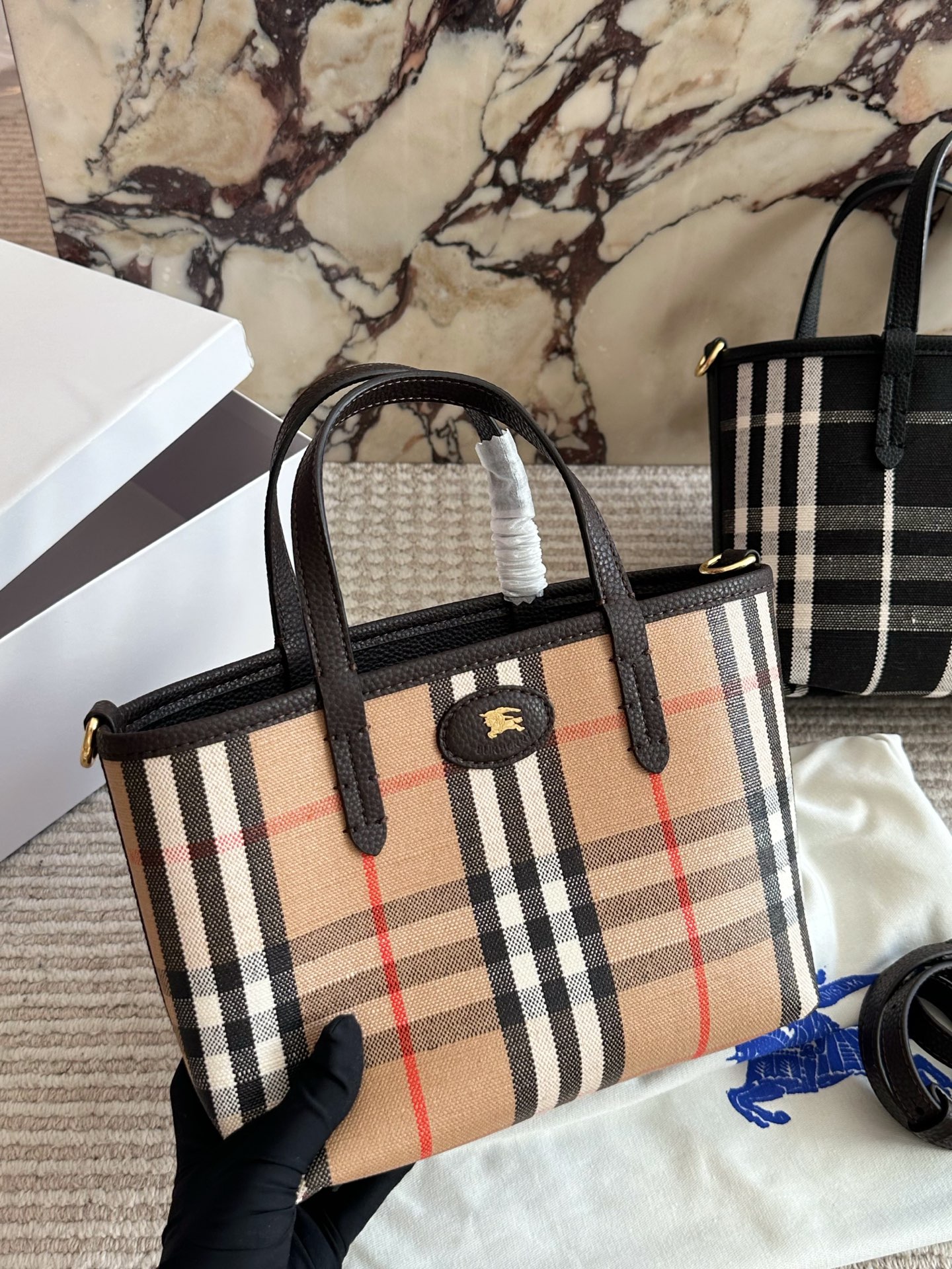 p190 双面tote Burberry家最新格纹迷你托特包，选用棉质帆布面料打造，格子面料搭配光滑皮革顶部提柄，有可调式斜背带。 顶部皮革提柄 可调式网纹肩背带开放式包口设计，搭配磁扣开合内侧口袋采用磁扣开合 尺寸 22 18cm 配盒
