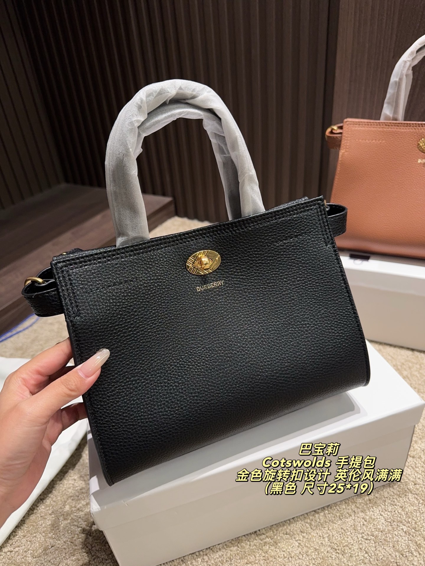 P220配盒⚠️尺寸25*19 Burberry 巴宝莉Cotswolds 手提包 采用粒面小牛皮，质感细腻耐用，低调奢华。金色旋转扣设计，英伦风满满，简约又精致。包身轻盈，容量适中，通勤或出行都很实用。内部空问合理，日常物品轻松收纳。黑色款百搭，适合多种穿搭，是实用与时尚兼具的经典之选的。