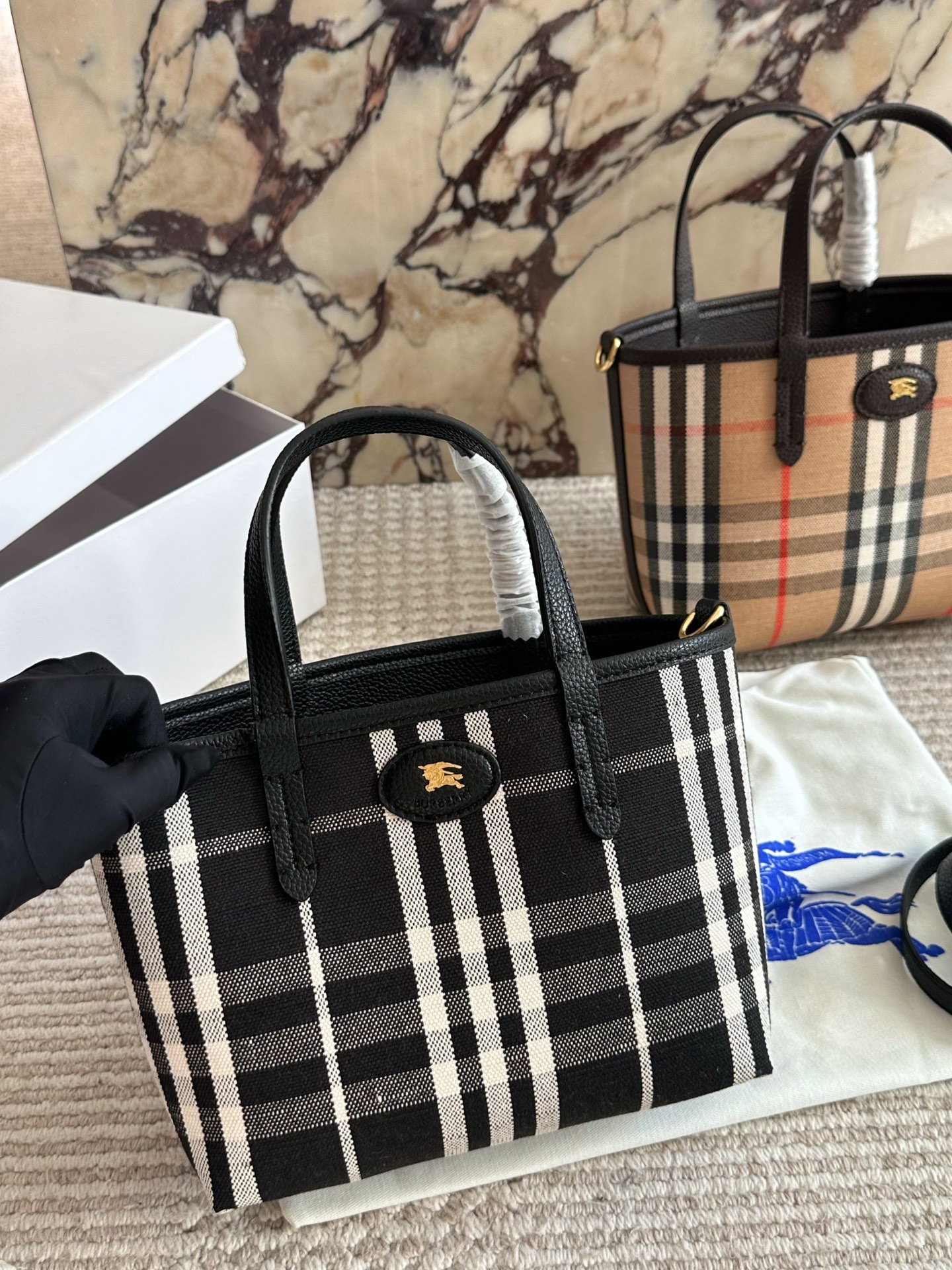 p190 双面tote Burberry家最新格纹迷你托特包，选用棉质帆布面料打造，格子面料搭配光滑皮革顶部提柄，有可调式斜背带。 顶部皮革提柄 可调式网纹肩背带开放式包口设计，搭配磁扣开合内侧口袋采用磁扣开合 尺寸 22 18cm 配盒
