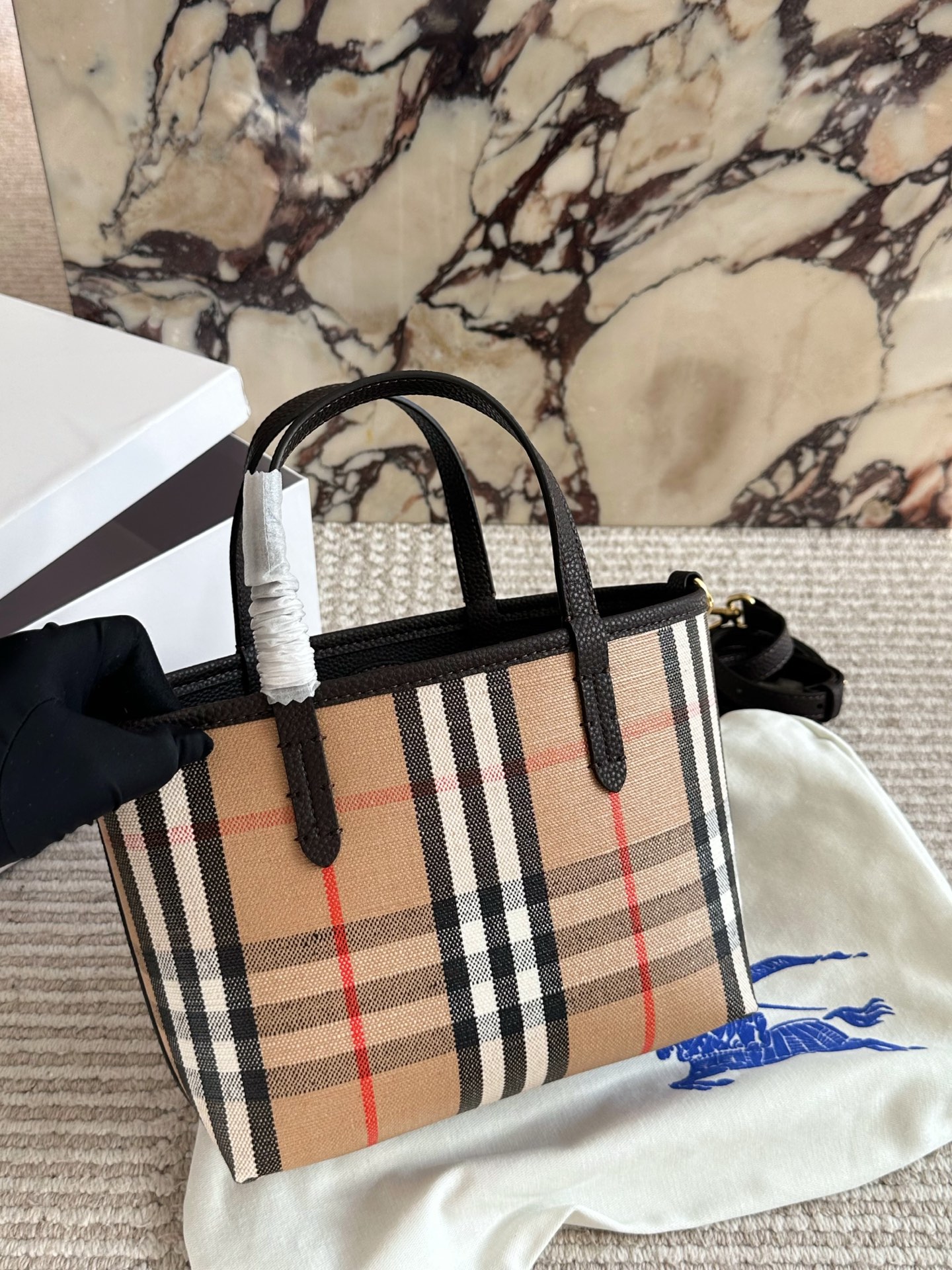 p190 双面tote Burberry家最新格纹迷你托特包，选用棉质帆布面料打造，格子面料搭配光滑皮革顶部提柄，有可调式斜背带。 顶部皮革提柄 可调式网纹肩背带开放式包口设计，搭配磁扣开合内侧口袋采用磁扣开合 尺寸 22 18cm 配盒
