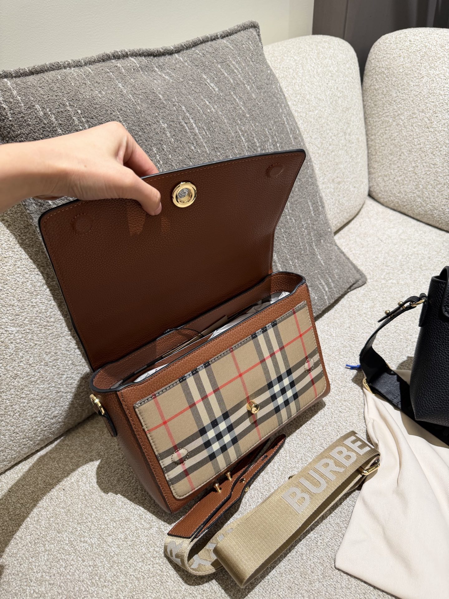 Burberry Note邮差包p165 Burberry Note邮差包，荔枝纹牛皮+经典格纹拼接，低 调又高级!25x17x8cm25x17x8cm，容量超能装，iPad、 雨伞都能放，通勤日常都OK++。宽肩带可调节，减压又百搭,休闲西装都能配。包盖吸扣设计，开合方便，内部空间合理，实用性满分!荔枝纹耐磨耐用，日常通勤、旅行都很 适合，是Burberry经典款，真的很推荐入手!