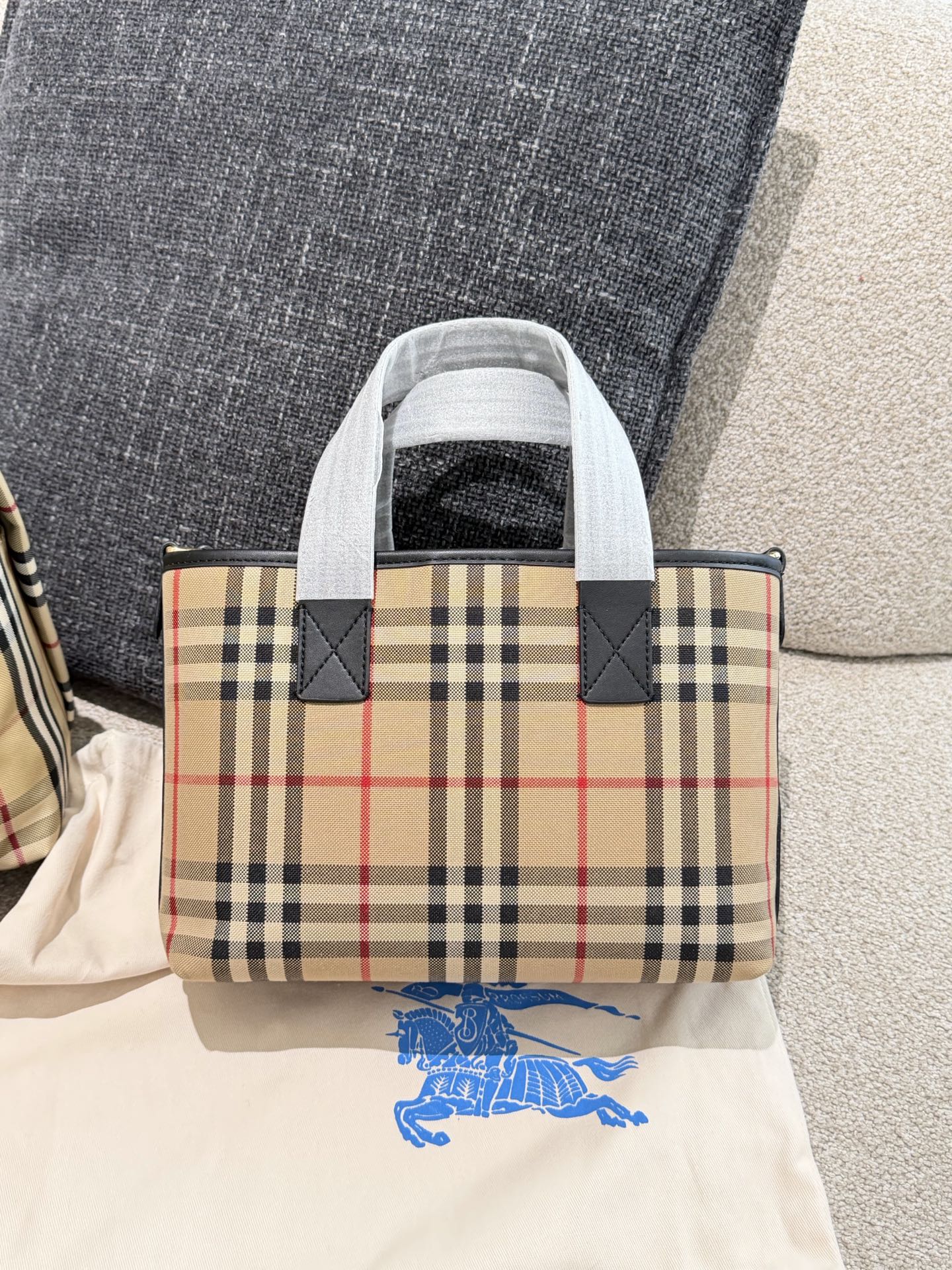 p150 Burberry家最新格纹迷你托特包,选用棉质帆布面料打造,格子面料搭配光滑皮革顶部提柄,有可调式斜背带。 顶部皮革提柄 可调式网纹肩背带开放式包口设计,搭配磁扣开合内侧口袋采用磁扣开合 尺寸 27/16.5/10