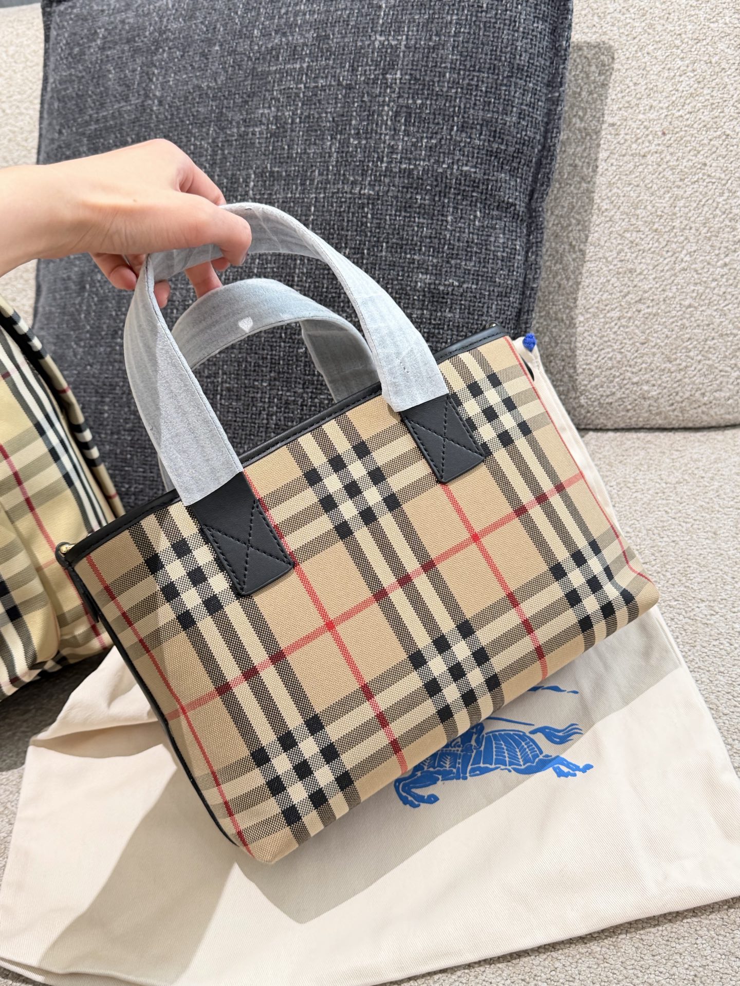 p150 Burberry家最新格纹迷你托特包,选用棉质帆布面料打造,格子面料搭配光滑皮革顶部提柄,有可调式斜背带。 顶部皮革提柄 可调式网纹肩背带开放式包口设计,搭配磁扣开合内侧口袋采用磁扣开合 尺寸 27/16.5/10