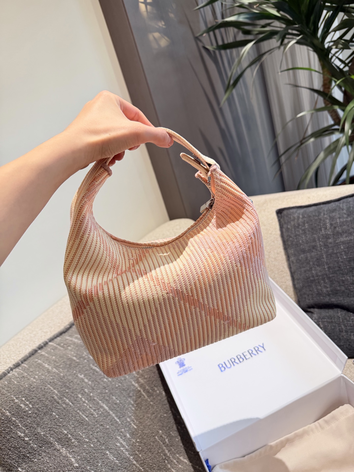 p215 Burberry粉色Peg腋下包 Burberry粉色Peg腋下包，采用柔软编织材质,触感温暖轻盈，春夏穿搭超适合!包身简约，经典格纹+蜜桃粉，清新优雅又百搭+。23x10.5x21.5cm约23x10.5x21.5cm，容量适中，通勤休闲都能hold住。双提手设计，手提肩背都OK，实用又时髦。Peg系列是Burberry经典款，时尚圈超受欢迎，春夏裙装或休闲装都能轻松搭配，日常出街必备!